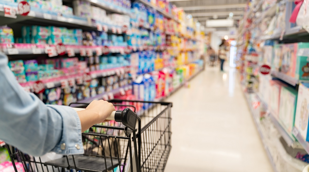 Asda - customer shopping in a supermarket concept.Shopping in supermarket a shopping cart view with motion blur.Close up of a woman shopping in a supermarket.Customer pushing a shopping cart in a supermarket.